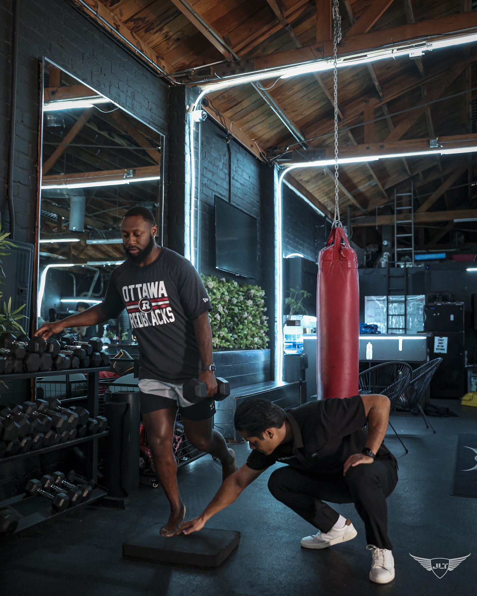 Dr. Tim assessing an athlete’s movement in a performance gym