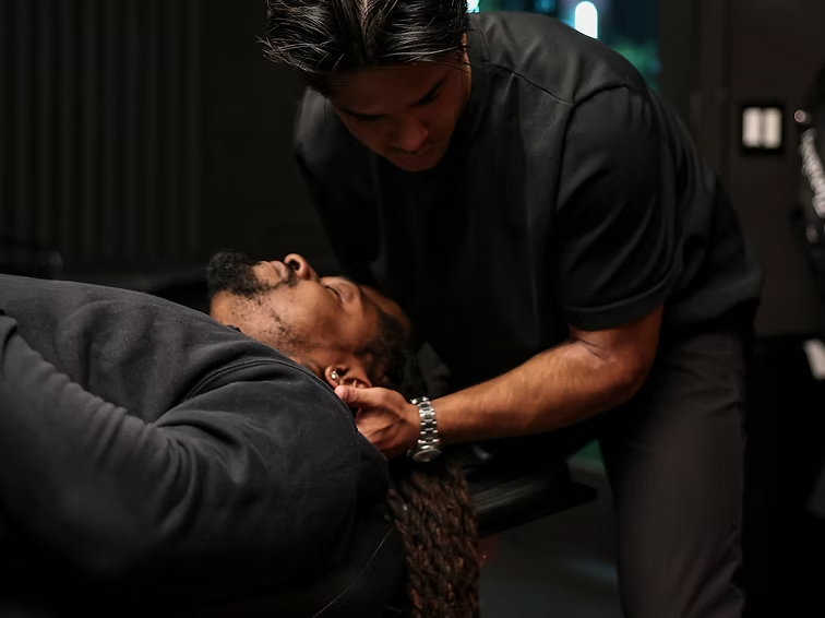 Dr. Tim providing hands-on neck care to an athlete on a treatment table